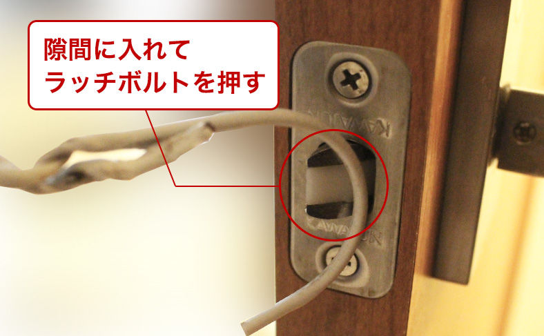 ハンガーでラッチボルトを押す