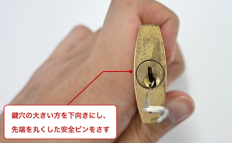 丸く曲げた安全ピンをさす