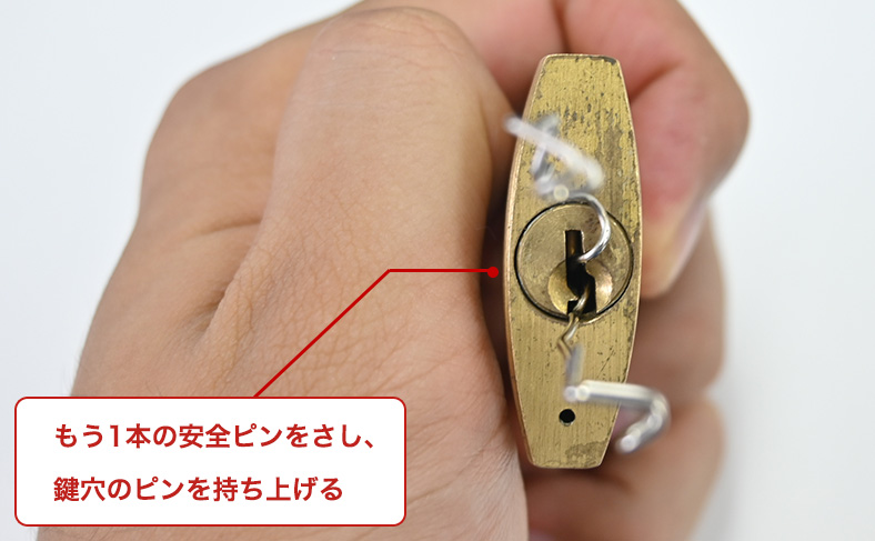 少し曲げた安全ピンをさす