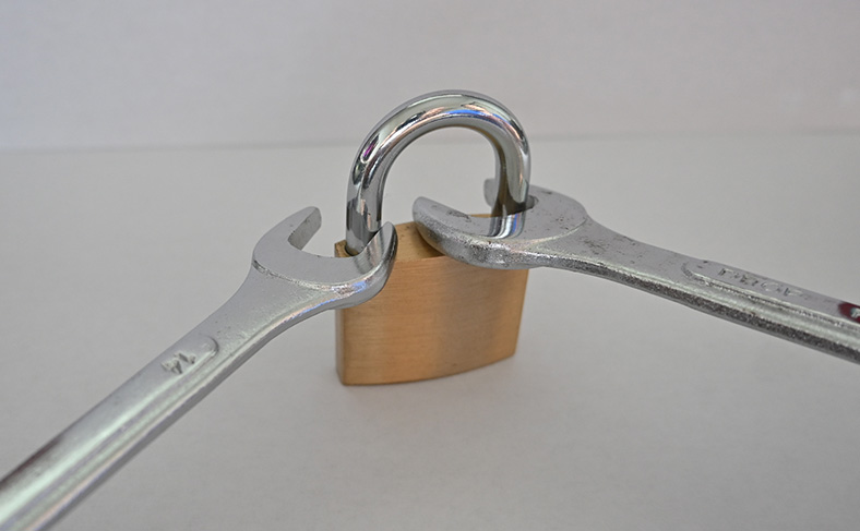 スパナを南京錠のU字部分に入れる