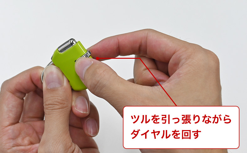 ツルを引っ張りながらダイヤルを回す